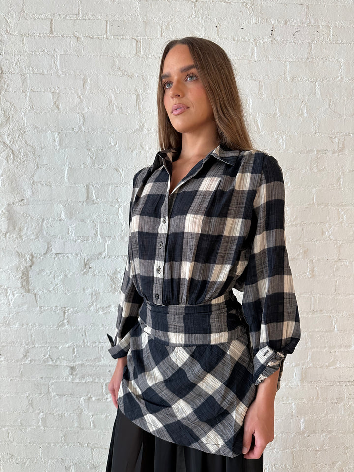 Woman wearing black checkered maxi dress with sheer maxi skirt bottom.