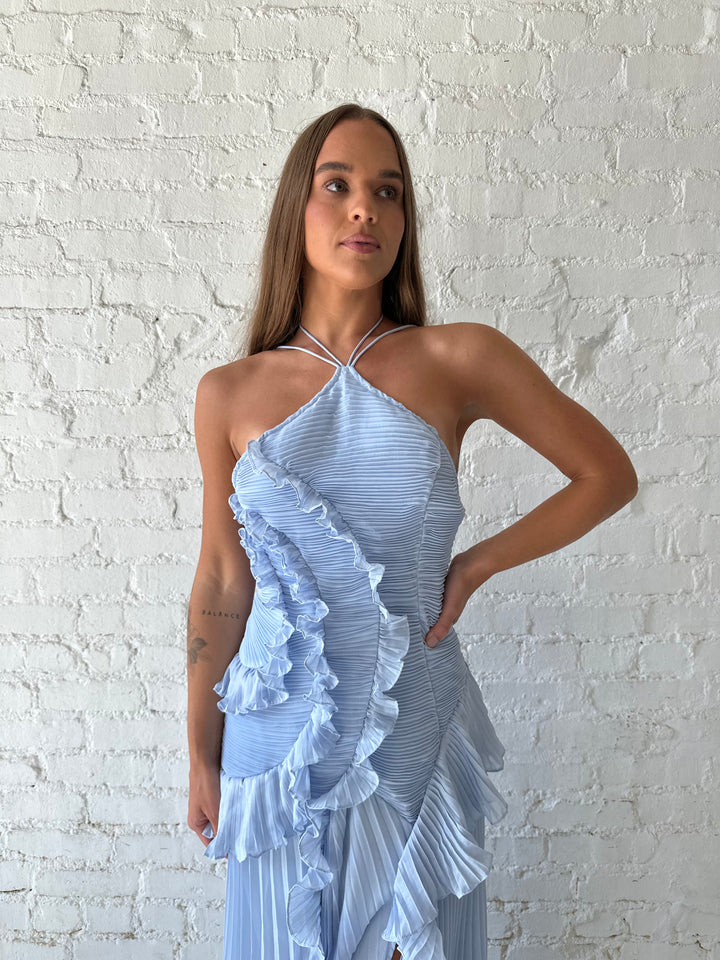 Woman wearing blue chiffon textured midi dress with halter neckline.