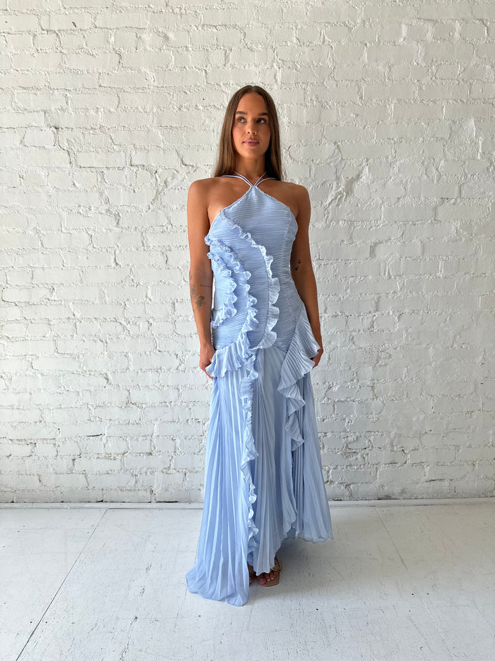 Woman wearing blue chiffon textured midi dress with halter neckline.