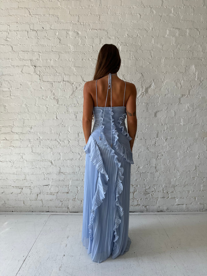 Woman wearing blue chiffon textured midi dress with halter neckline.