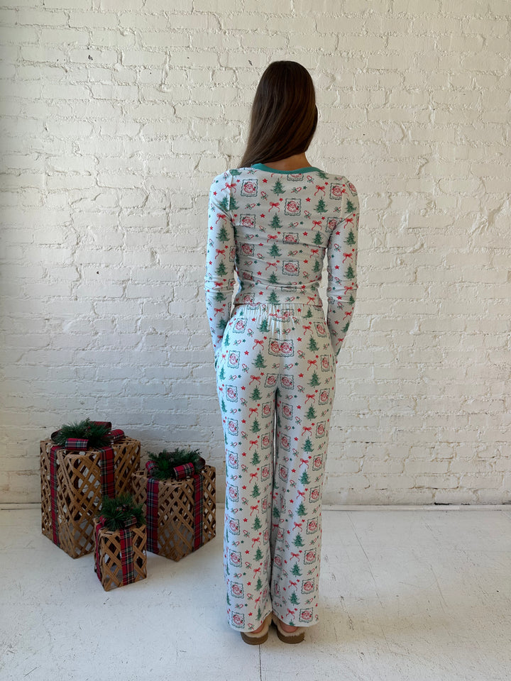 Woman wearing vintage Christmas postage pattern pajama set. 