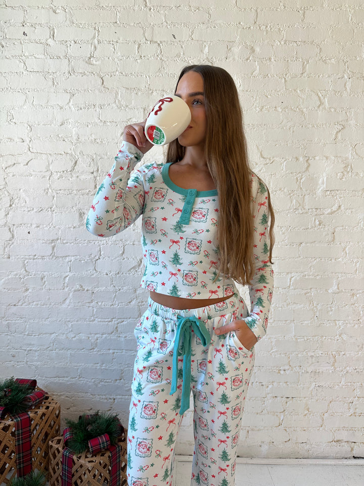 Woman wearing vintage Christmas postage pattern pajama set. 