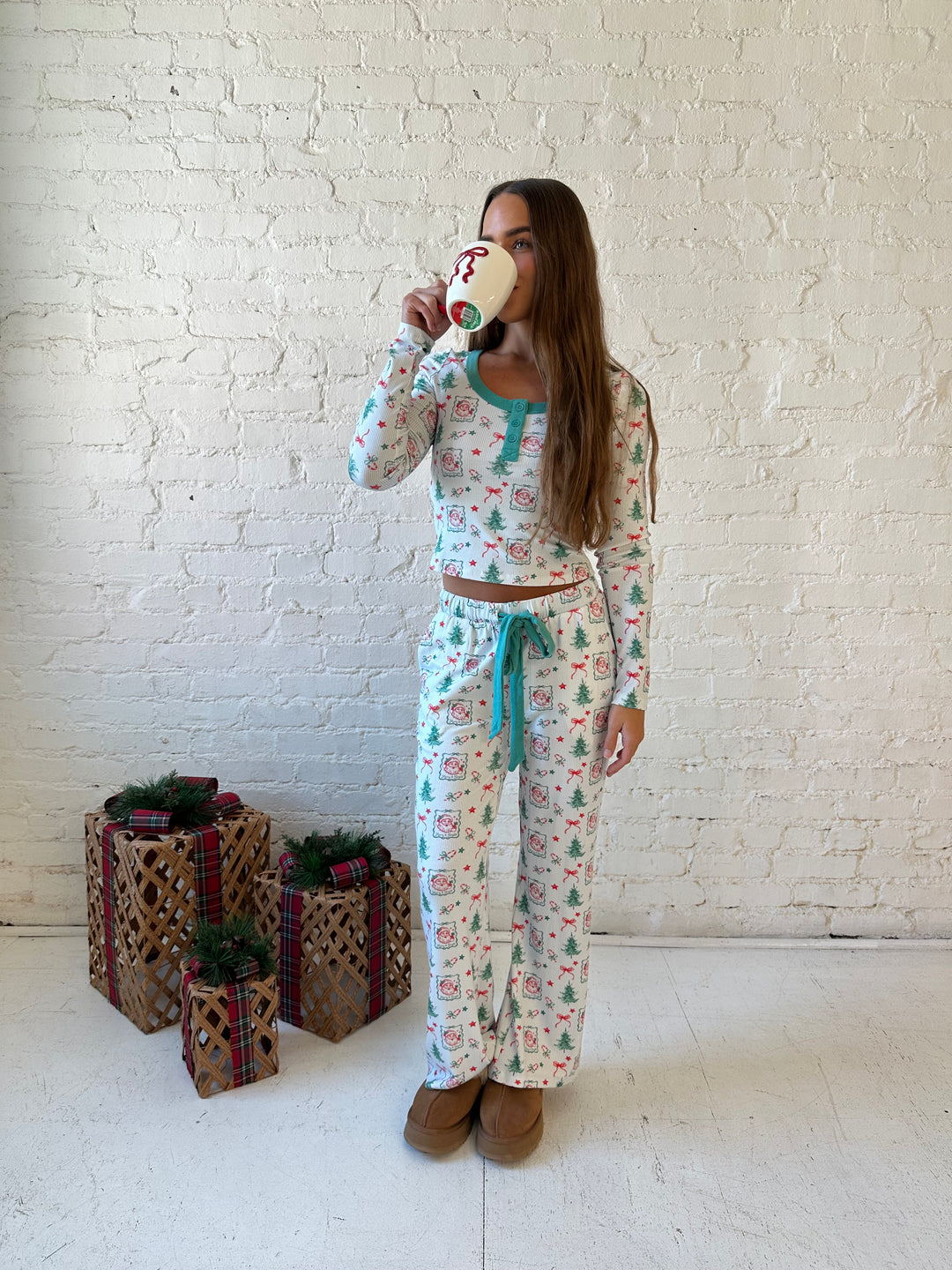 Woman wearing vintage Christmas postage pattern pajama set. 