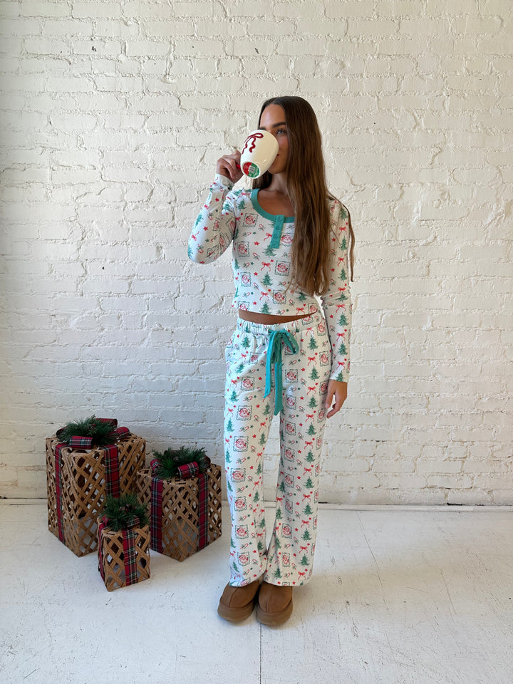 Woman wearing vintage Christmas postage pattern pajama set. 