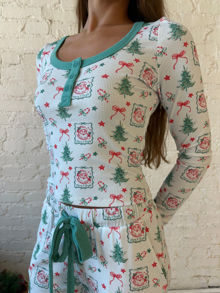 Woman wearing vintage Christmas postage pattern pajama set. 