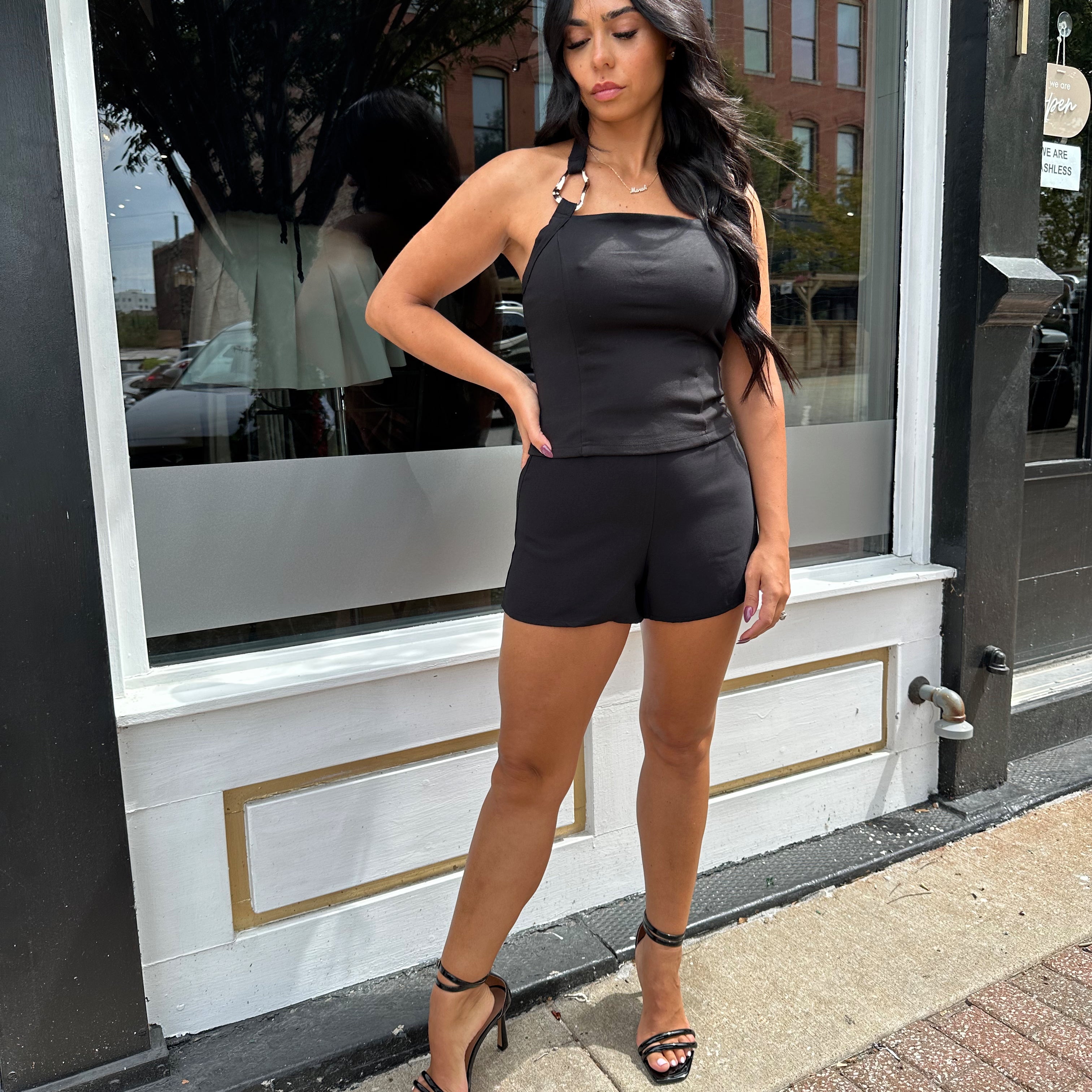 Woman wearing black halter top with chain link detail. 