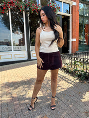 Woman wearing high waisted burgundy brushed denim mini skort. 