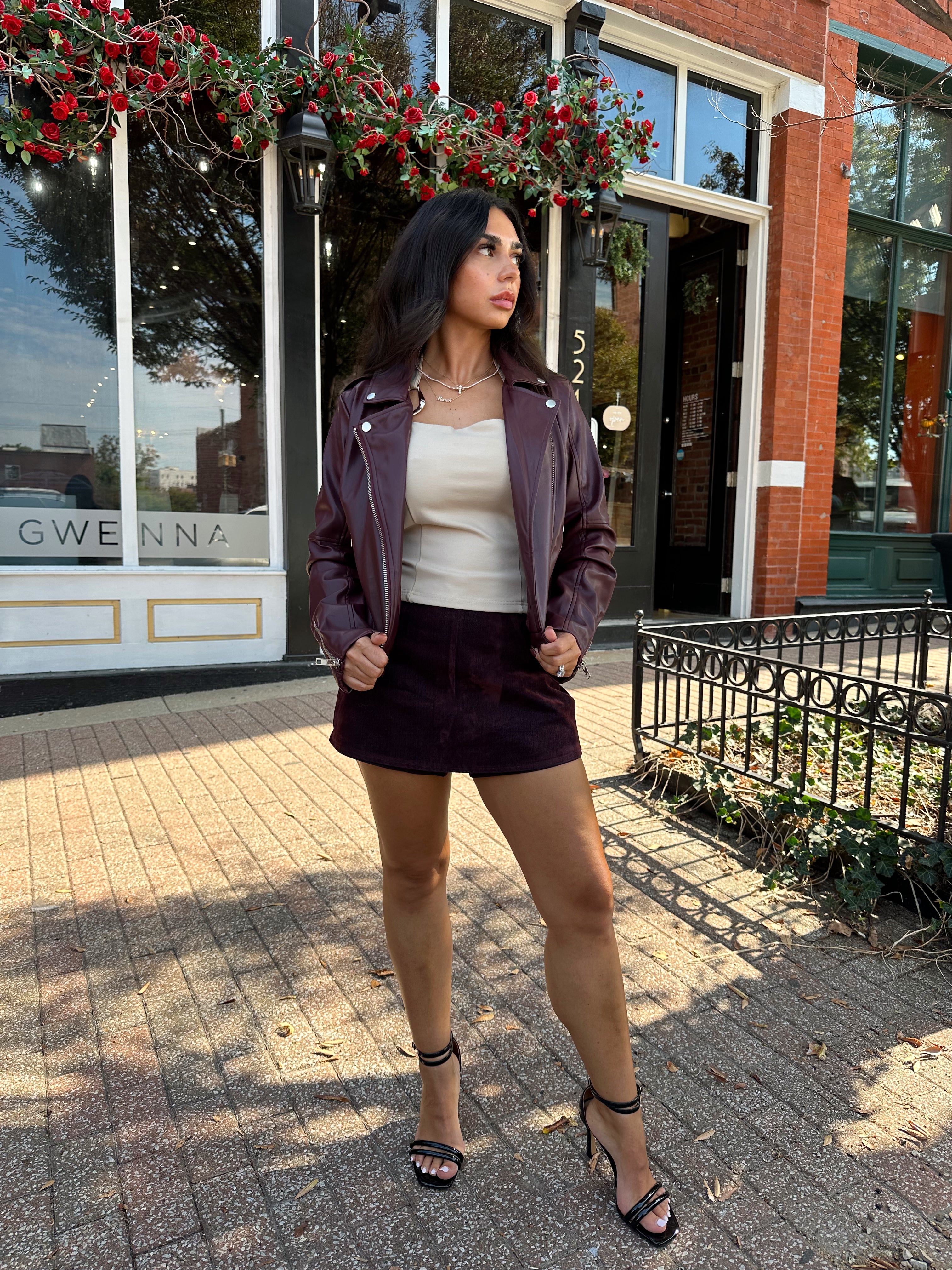 Woman wearing high waisted burgundy brushed denim mini skort. 