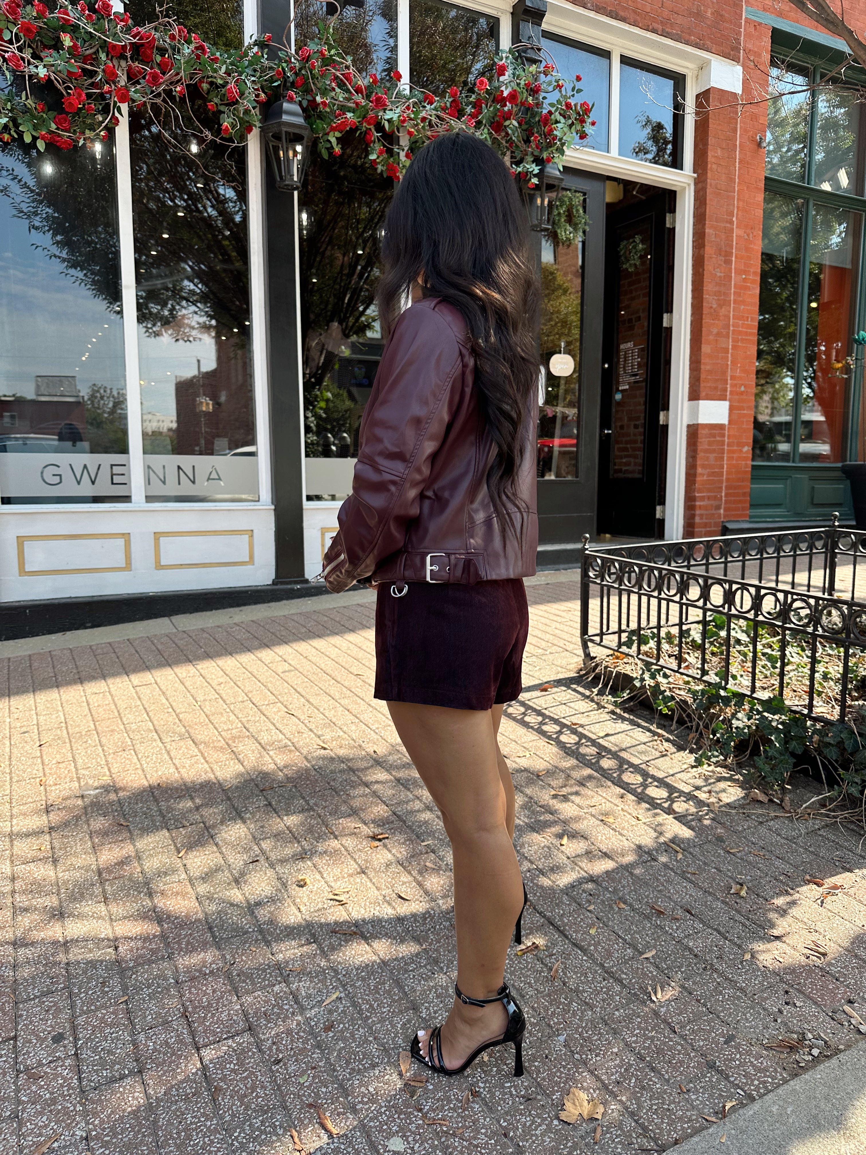 Woman wearing high waisted burgundy brushed denim mini skort. 