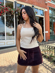 Woman wearing high waisted burgundy brushed denim mini skort. 