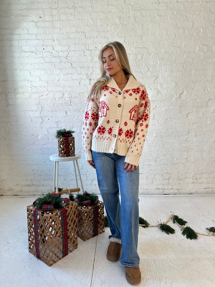 Woman wearing cream button down cardigan with red Christmas pattern all over.