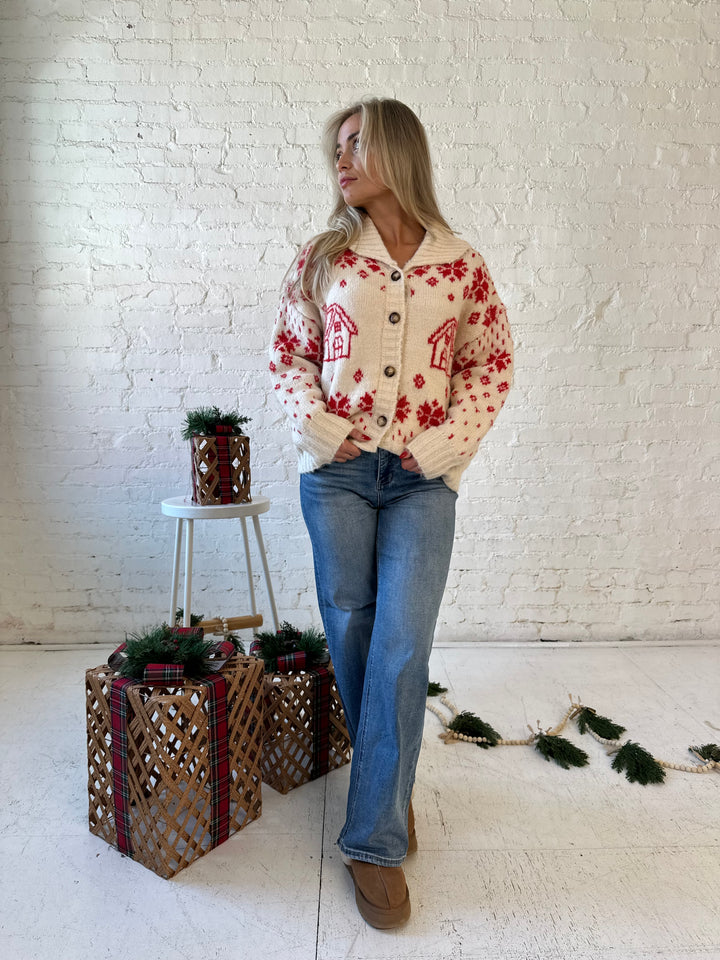 Woman wearing cream button down cardigan with red Christmas pattern all over.