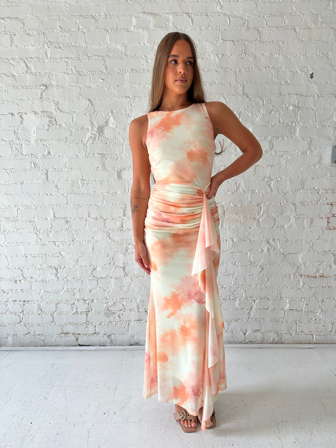 Woman wearing yellow watercolor maxi dress with high neckline, and ruched side detailing. 
