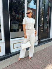 Ivory bouclé two piece set with gold button closure and wide leg pant. 