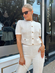 Ivory bouclé two piece set with gold button closure and wide leg pant. 