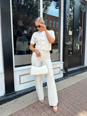 Ivory bouclé two piece set with gold button closure and wide leg pant. 