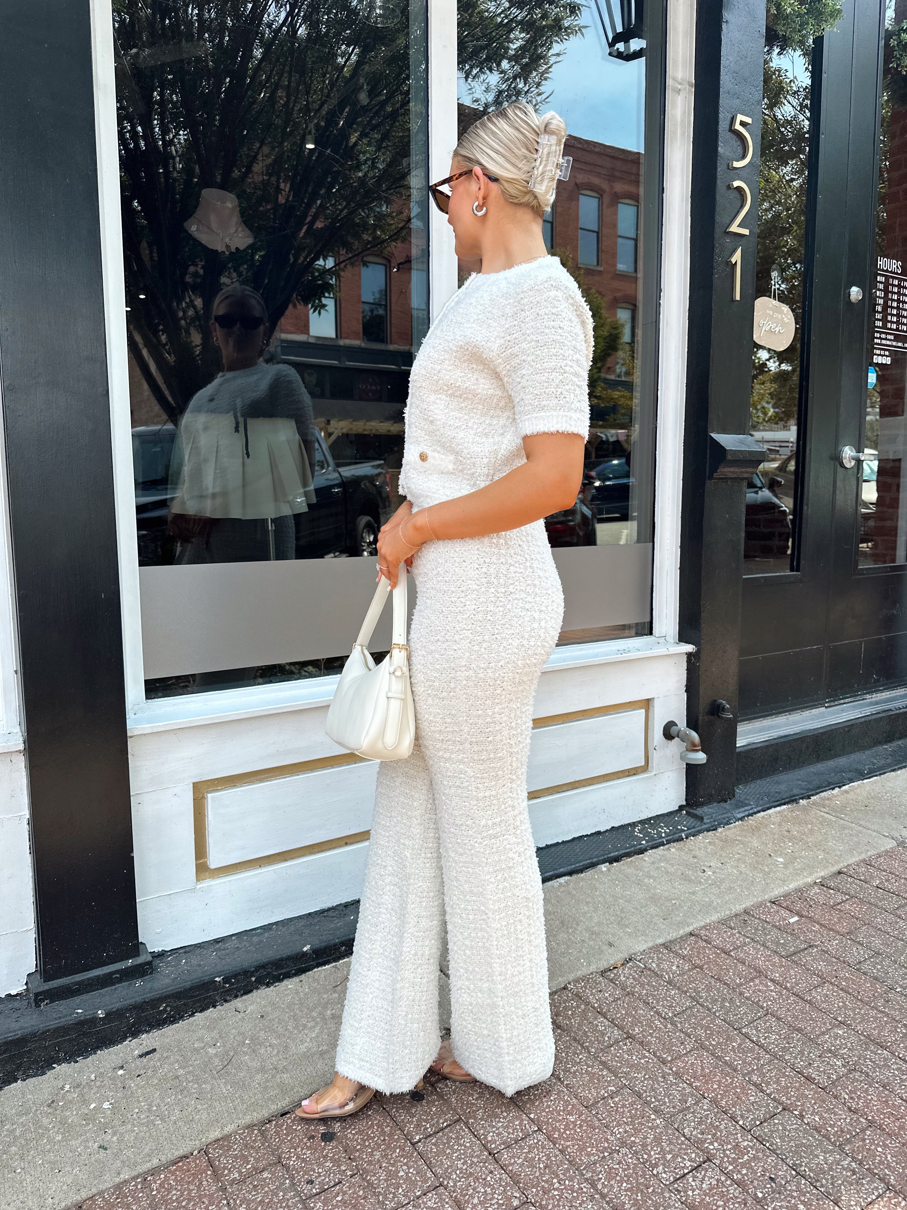 Ivory bouclé two piece set with gold button closure and wide leg pant. 