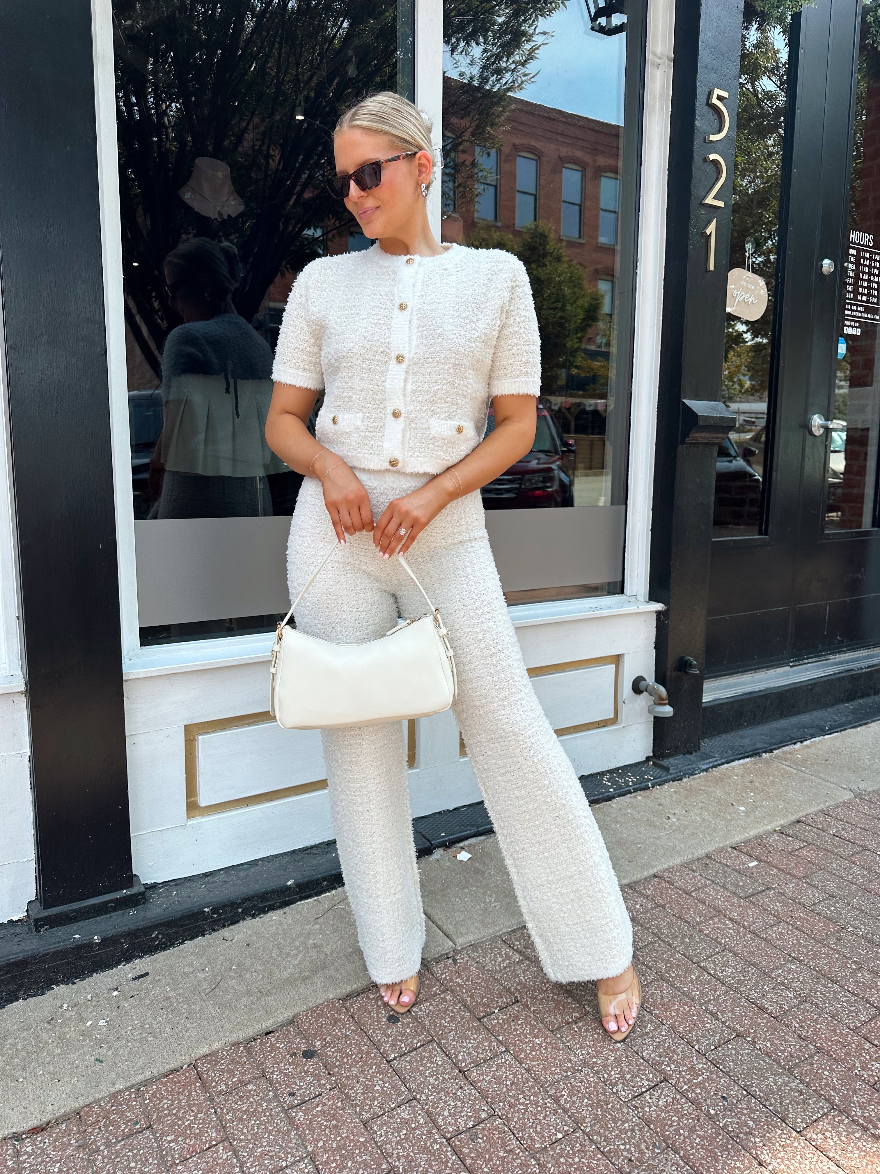 Ivory bouclé two piece set with gold button closure and wide leg pant. 