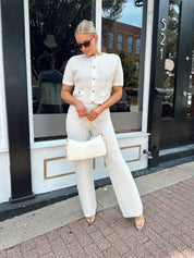 Ivory bouclé two piece set with gold button closure and wide leg pant. 