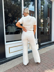 Ivory bouclé two piece set with gold button closure and wide leg pant. 