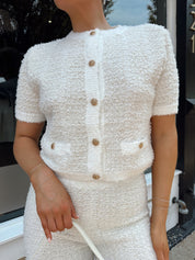 Ivory bouclé two piece set with gold button closure and wide leg pant. 