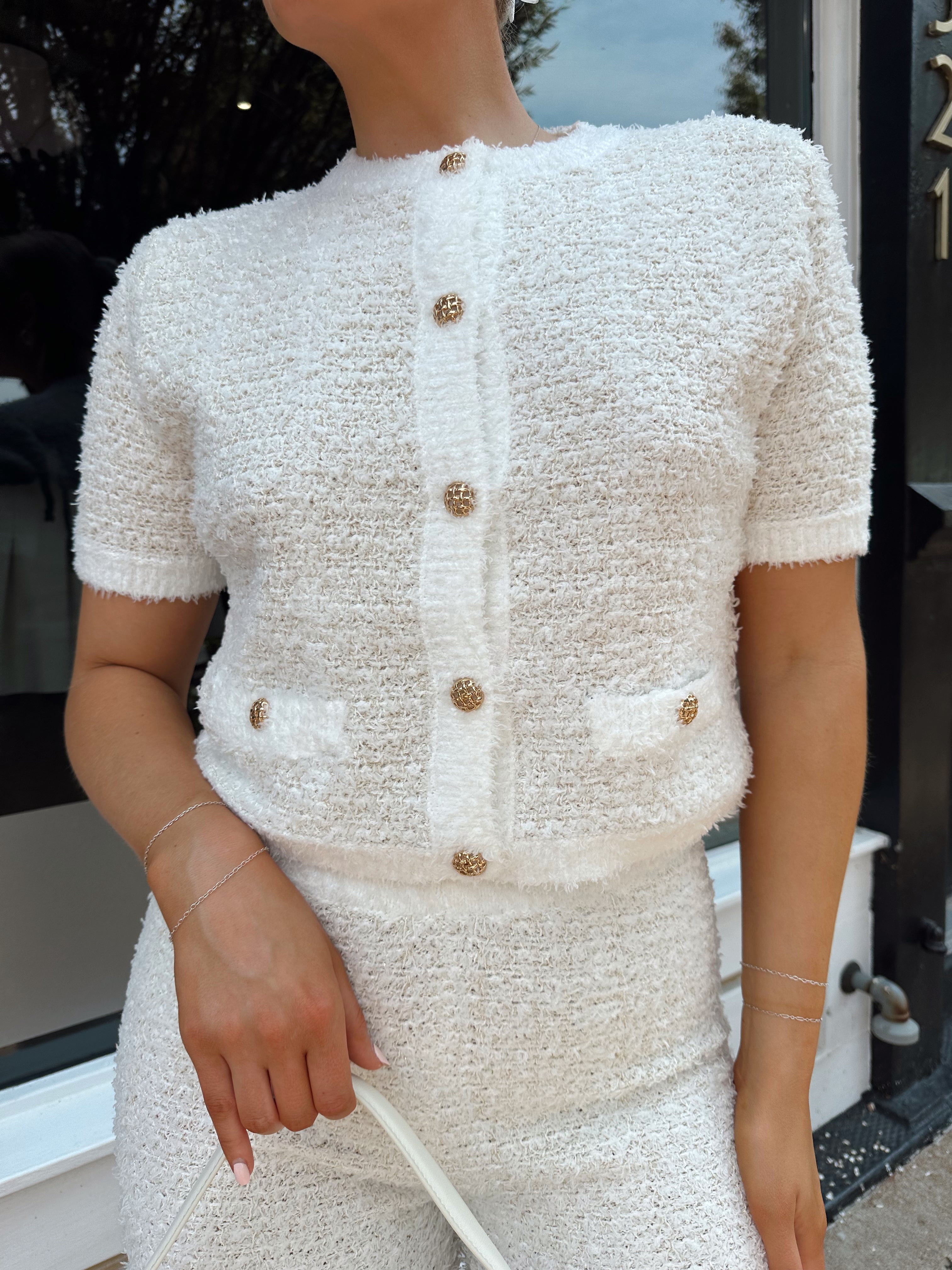 Ivory bouclé two piece set with gold button closure and wide leg pant. 