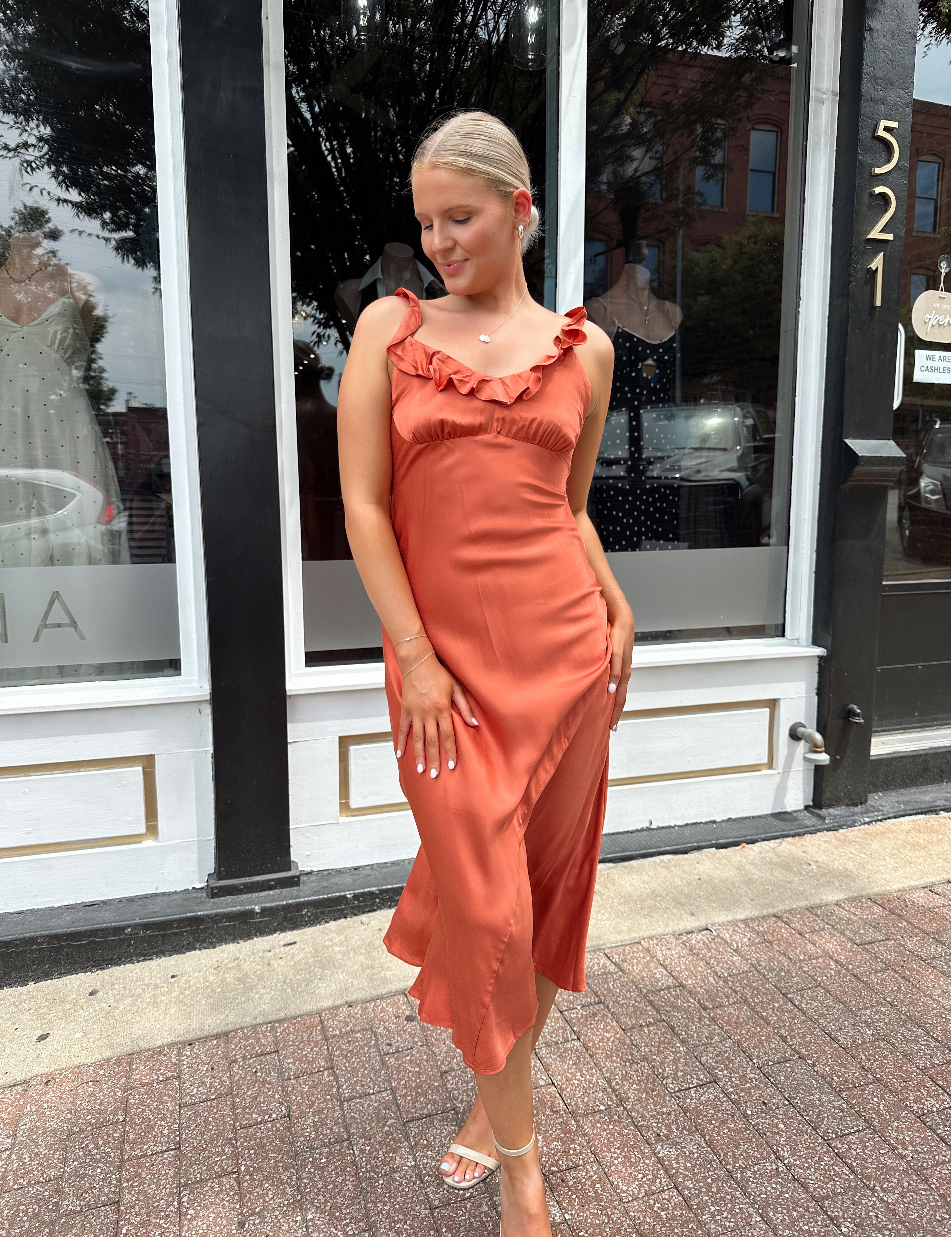 Burnt orange satin midi dress with ruffle trim. Perfect fall wedding guest dress.