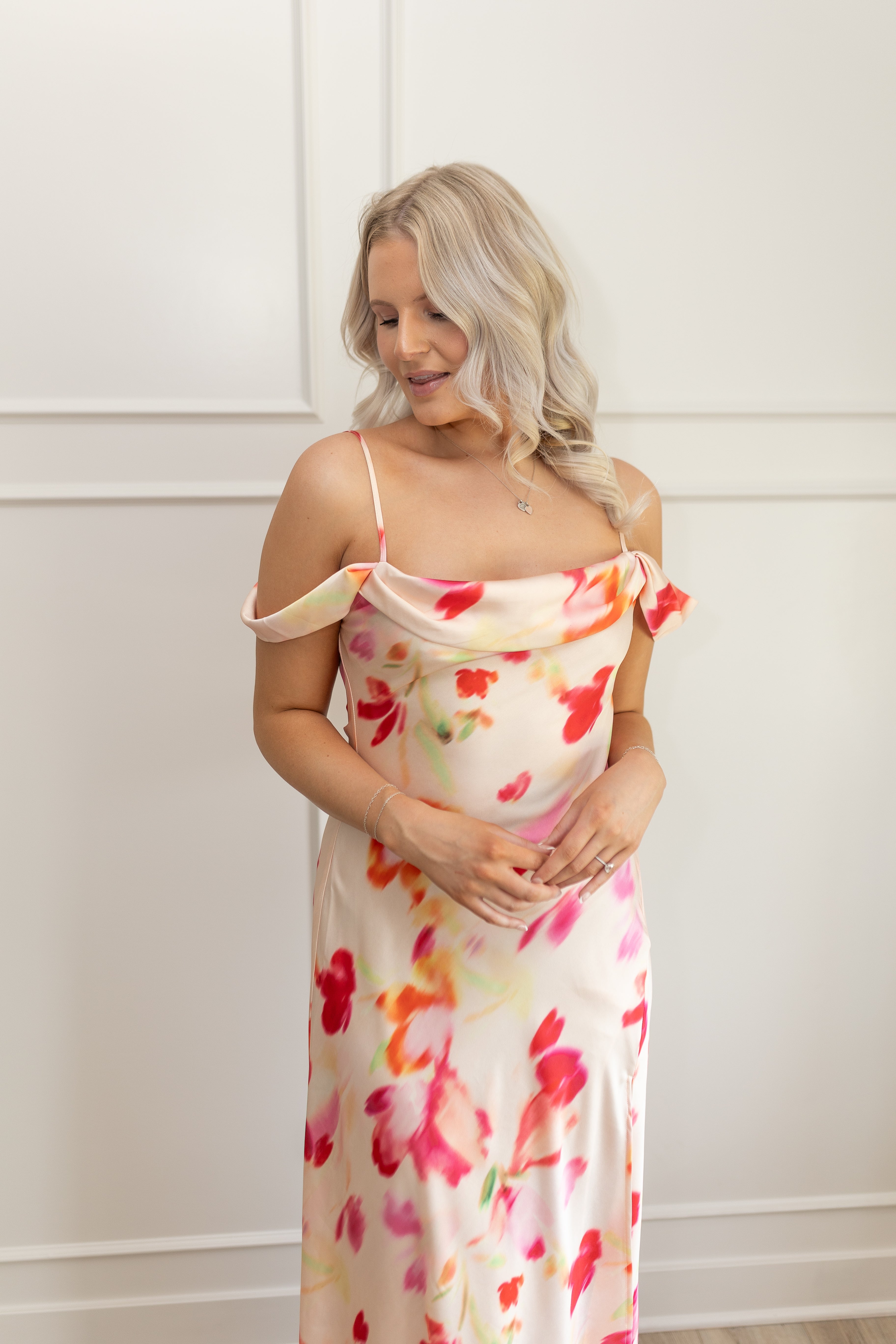 Model wearing off-the-shoulder floral midi dress with pink and red watercolor print