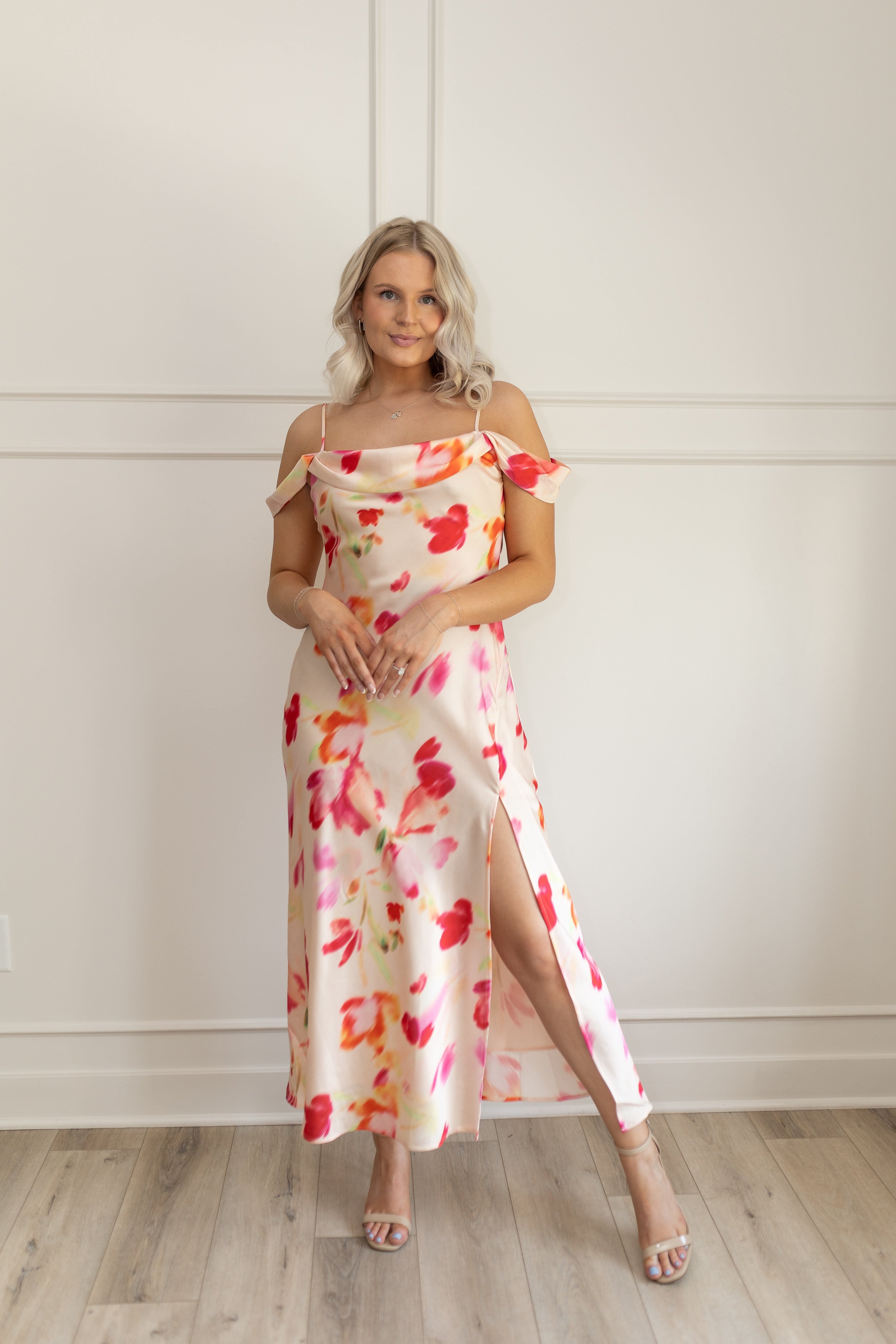Model wearing off-the-shoulder floral midi dress with pink and red watercolor print