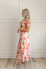 Model wearing off-the-shoulder floral midi dress with pink and red watercolor print