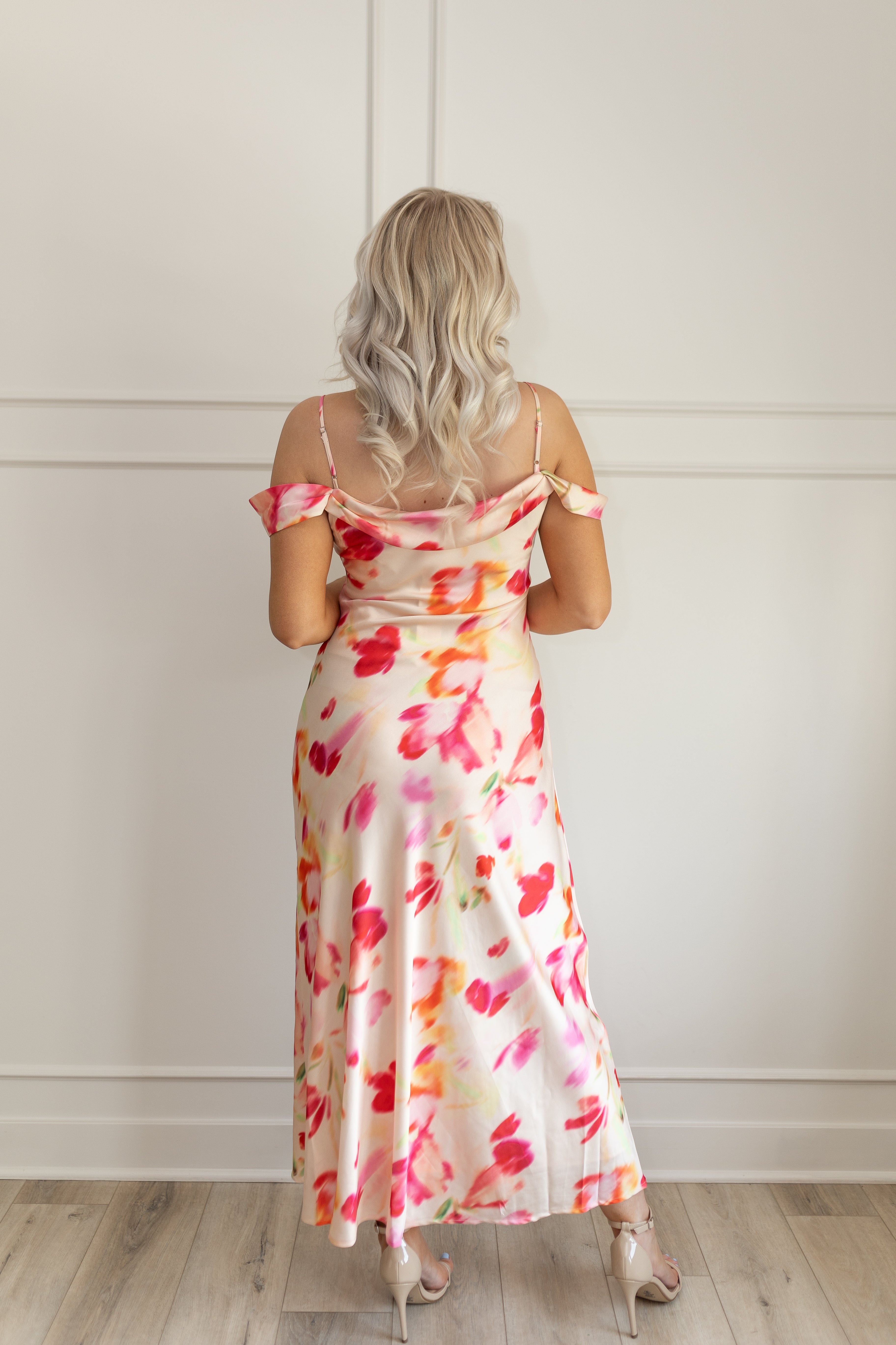 Model wearing off-the-shoulder floral midi dress with pink and red watercolor print