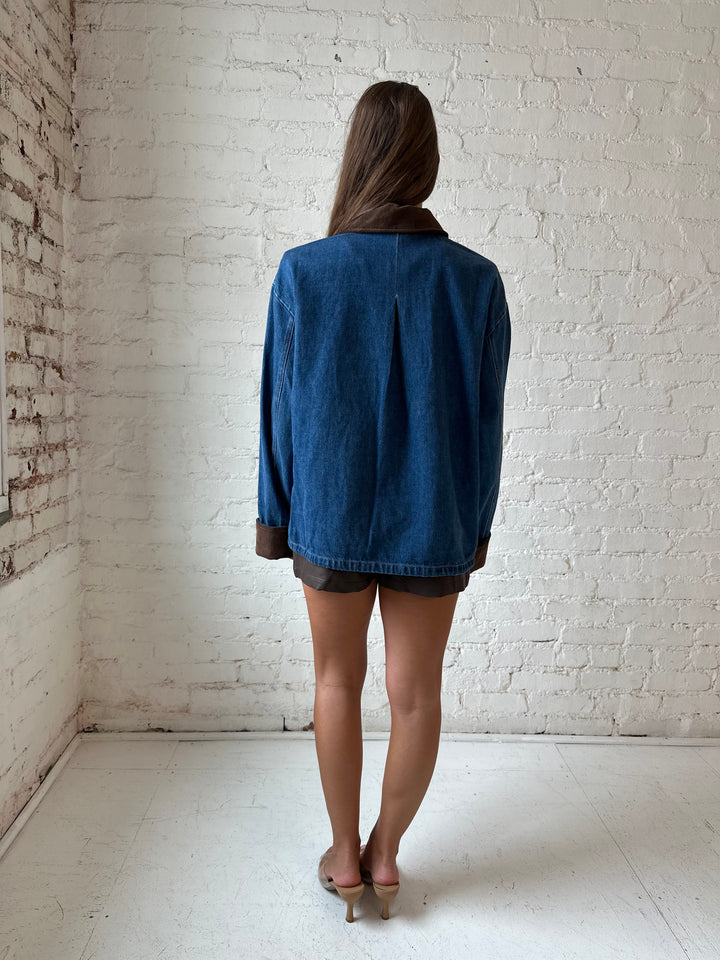Woman wearing dark wash denim bomber jacket with brown corduroy collar and wrist cuffs.