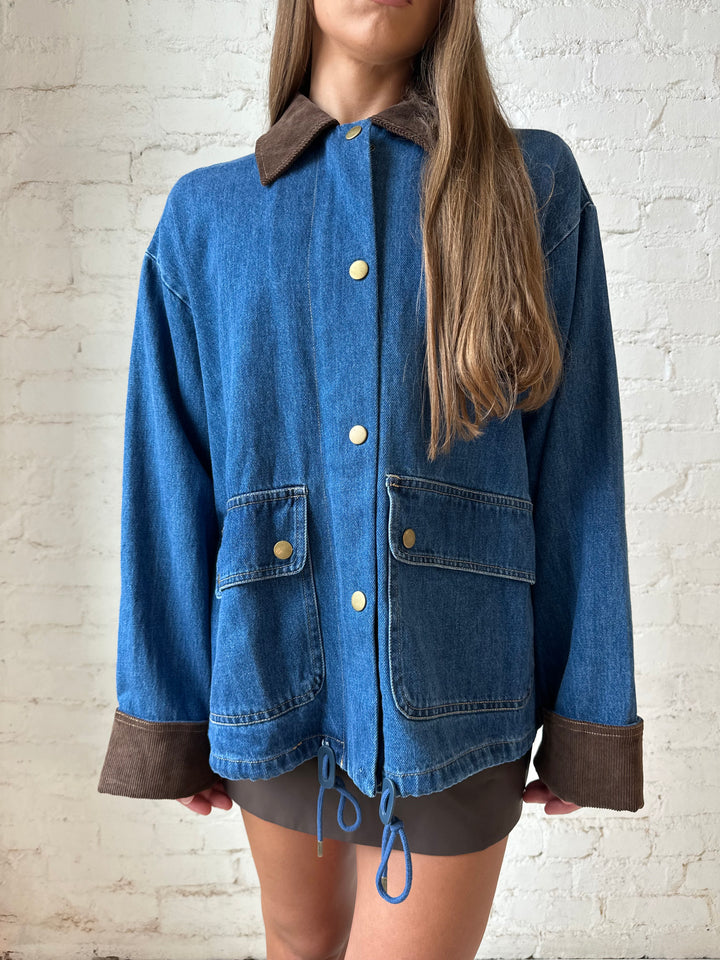 Woman wearing dark wash denim bomber jacket with brown corduroy collar and wrist cuffs.