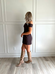 Woman wearing brown knit off the shoulder mini dress with pleated mini dress.