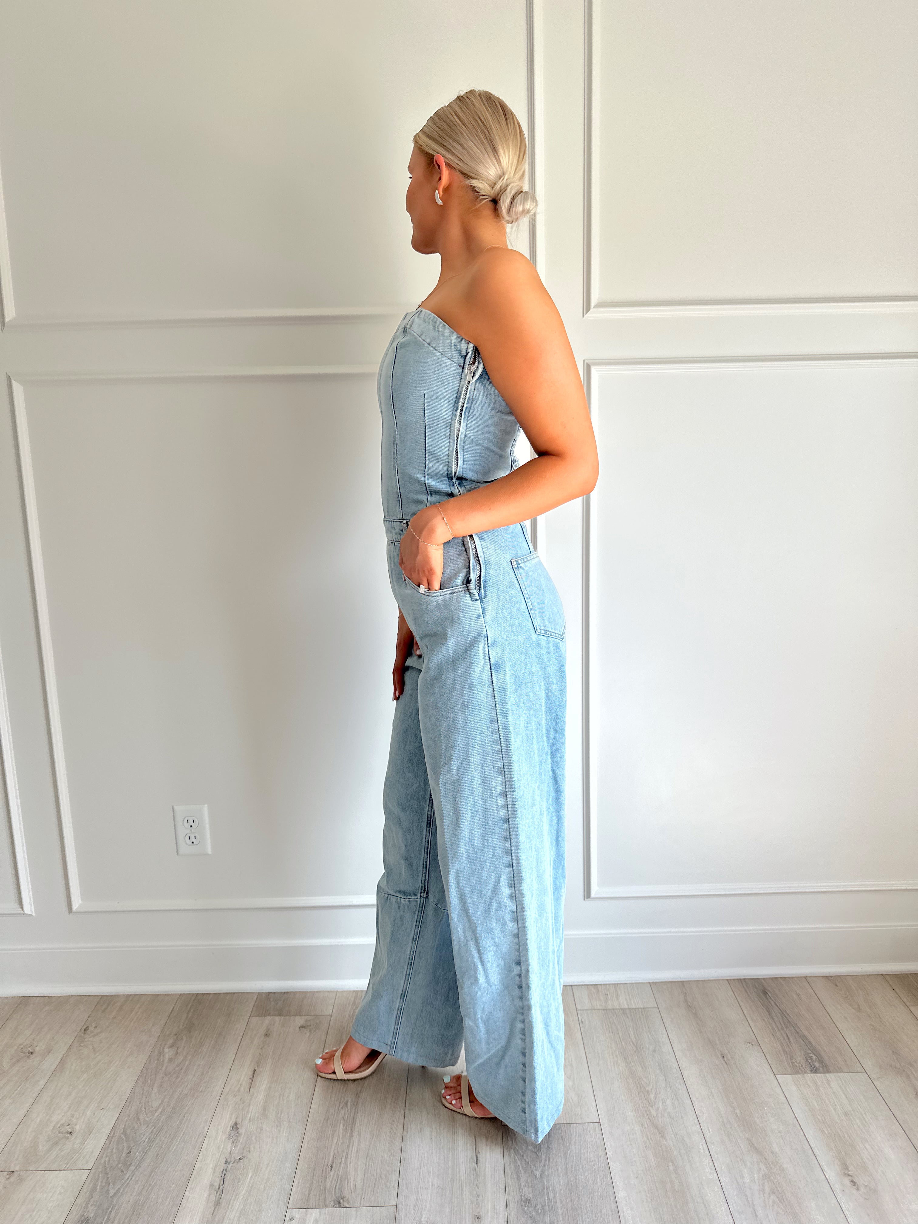 Light wash denim wide leg jumpsuit with functional pockets.