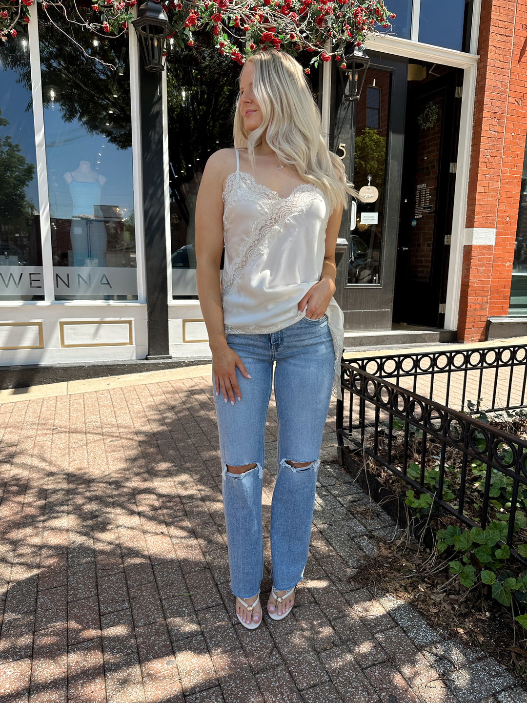 Woman wearing high rise distress jean with raw hem. 