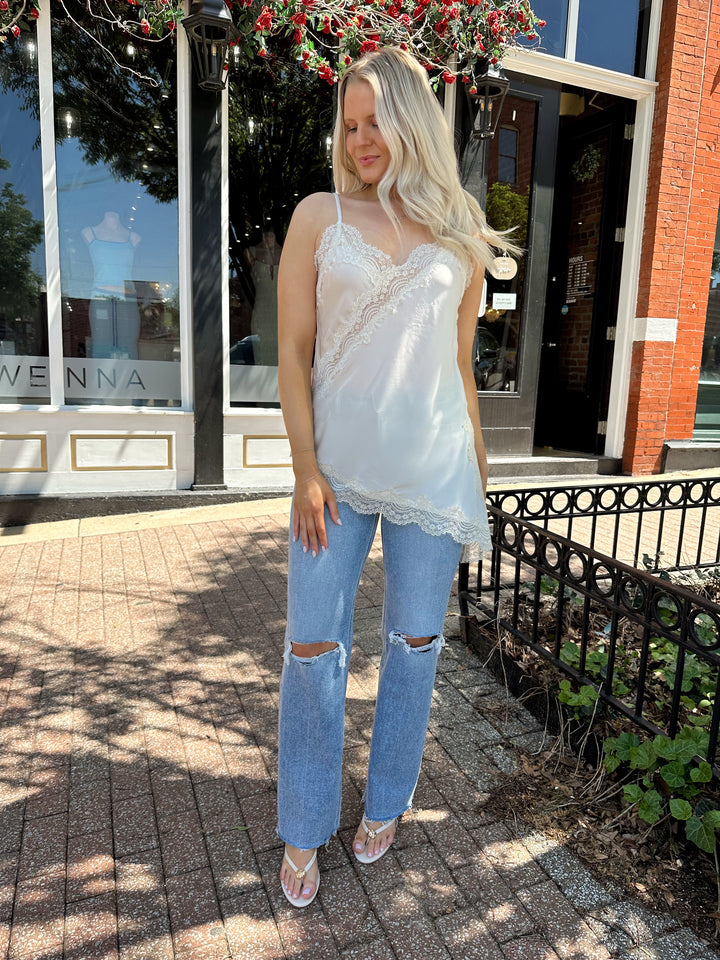 Woman wearing high rise distress jean with raw hem. 