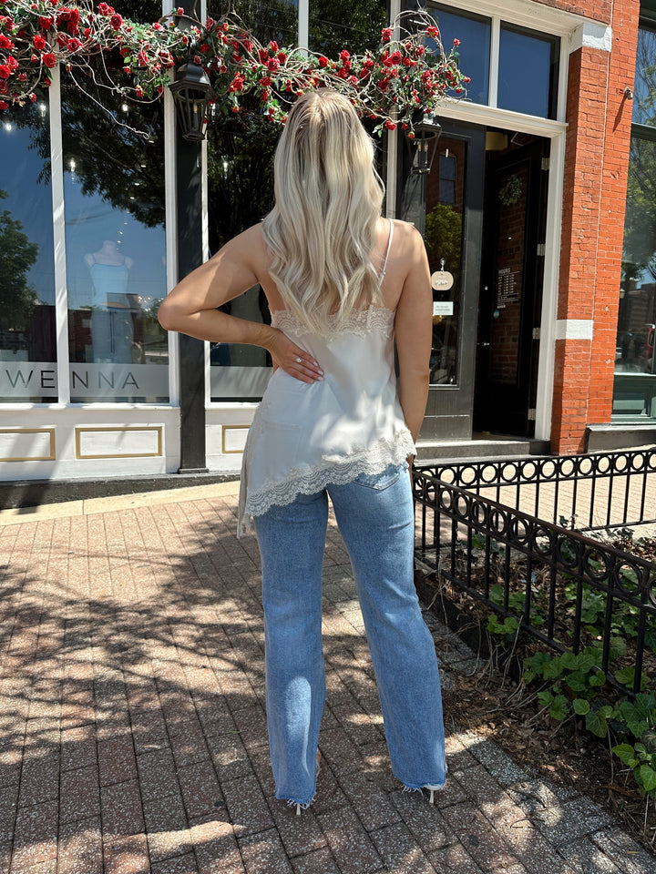 Woman wearing high rise distress jean with raw hem. 
