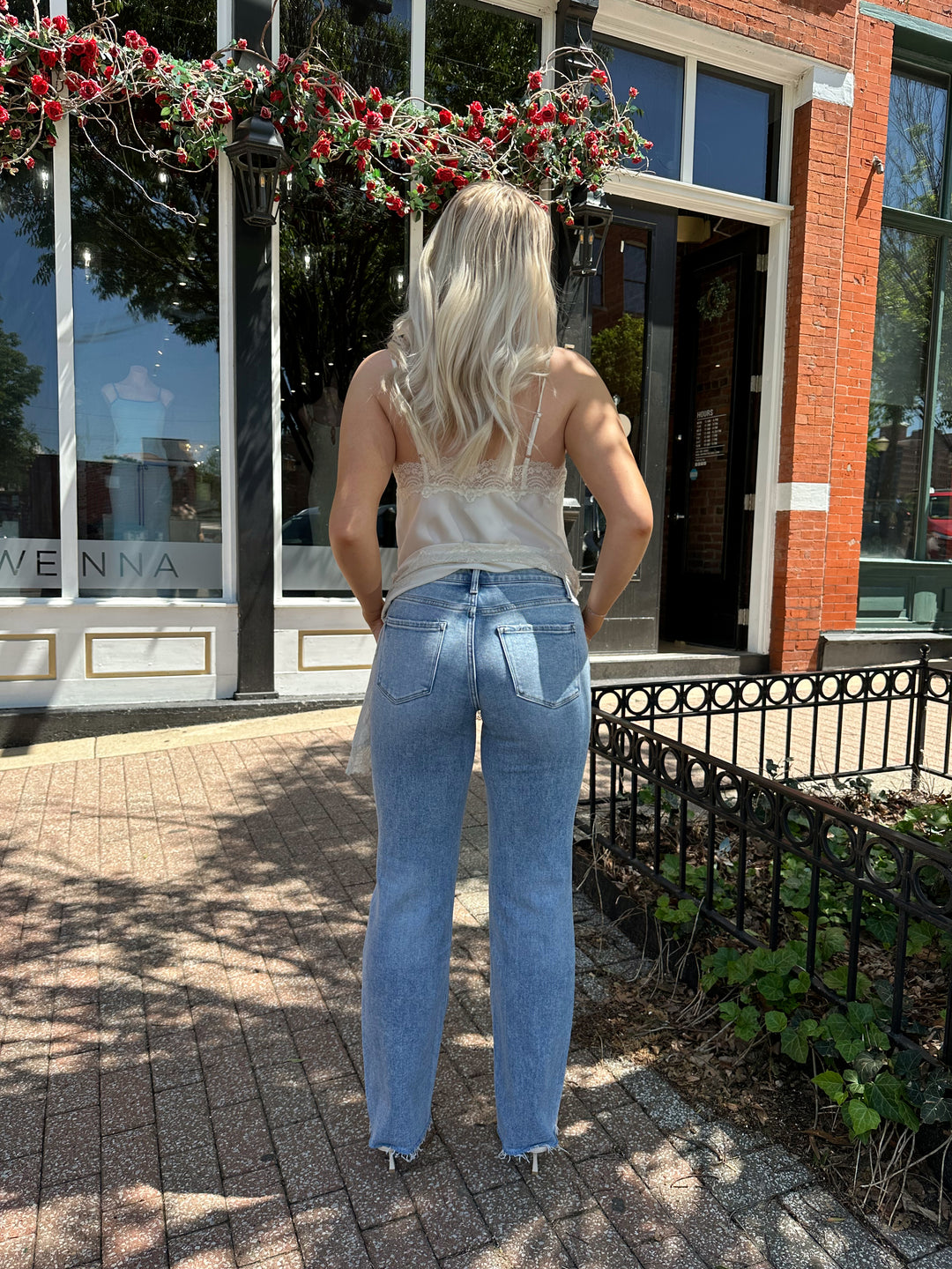 Woman wearing high rise distress jean with raw hem. 