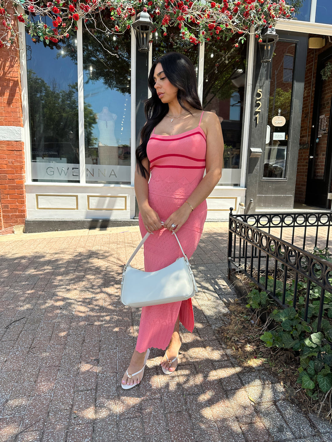 Woman wearing pink contrast knit midi dress with adjustable spaghetti traps.