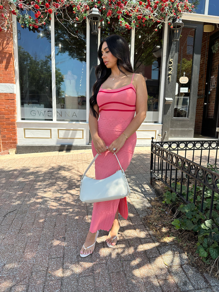 Woman wearing pink contrast knit midi dress with adjustable spaghetti traps.