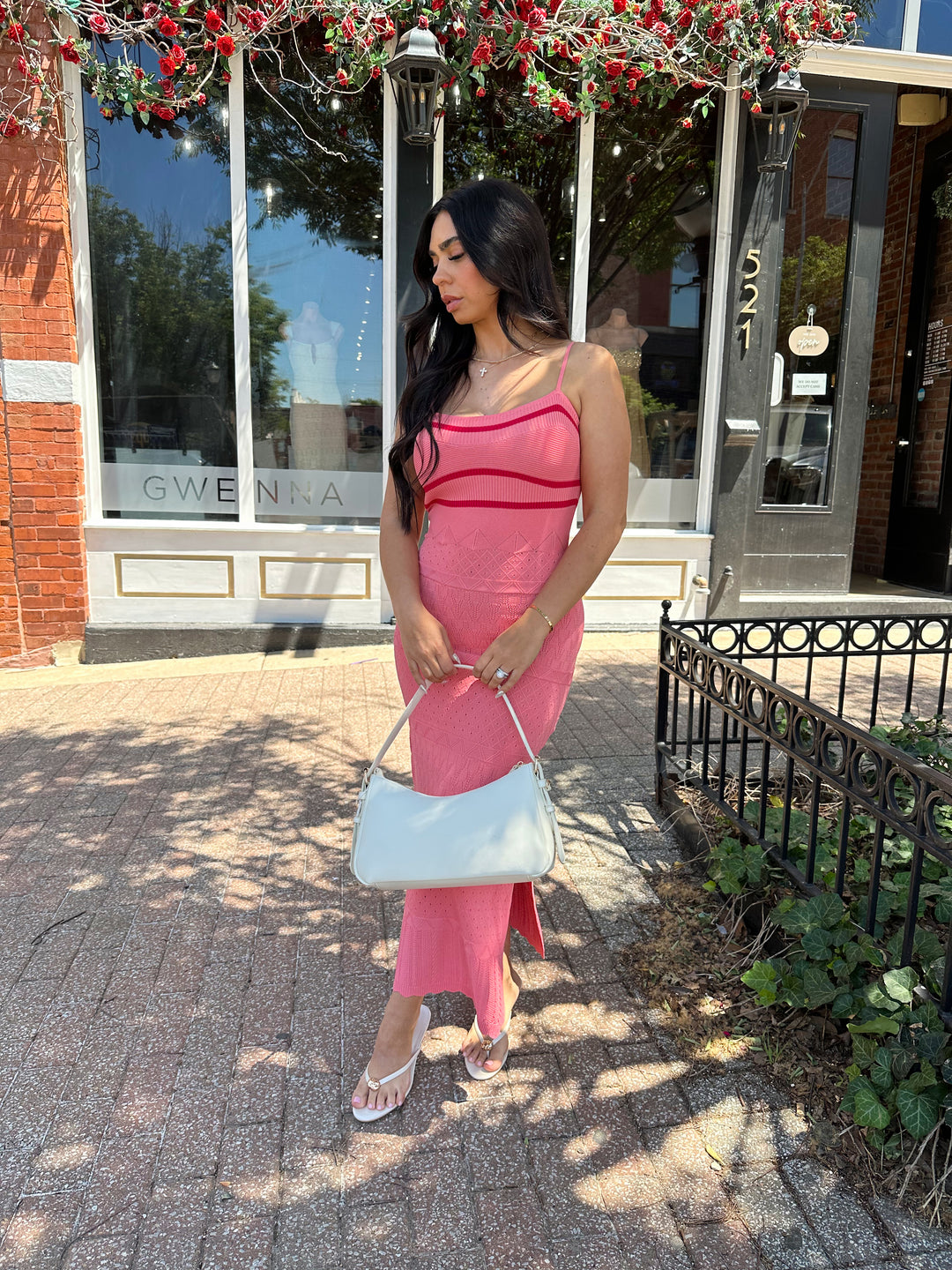 Woman wearing pink contrast knit midi dress with adjustable spaghetti traps.