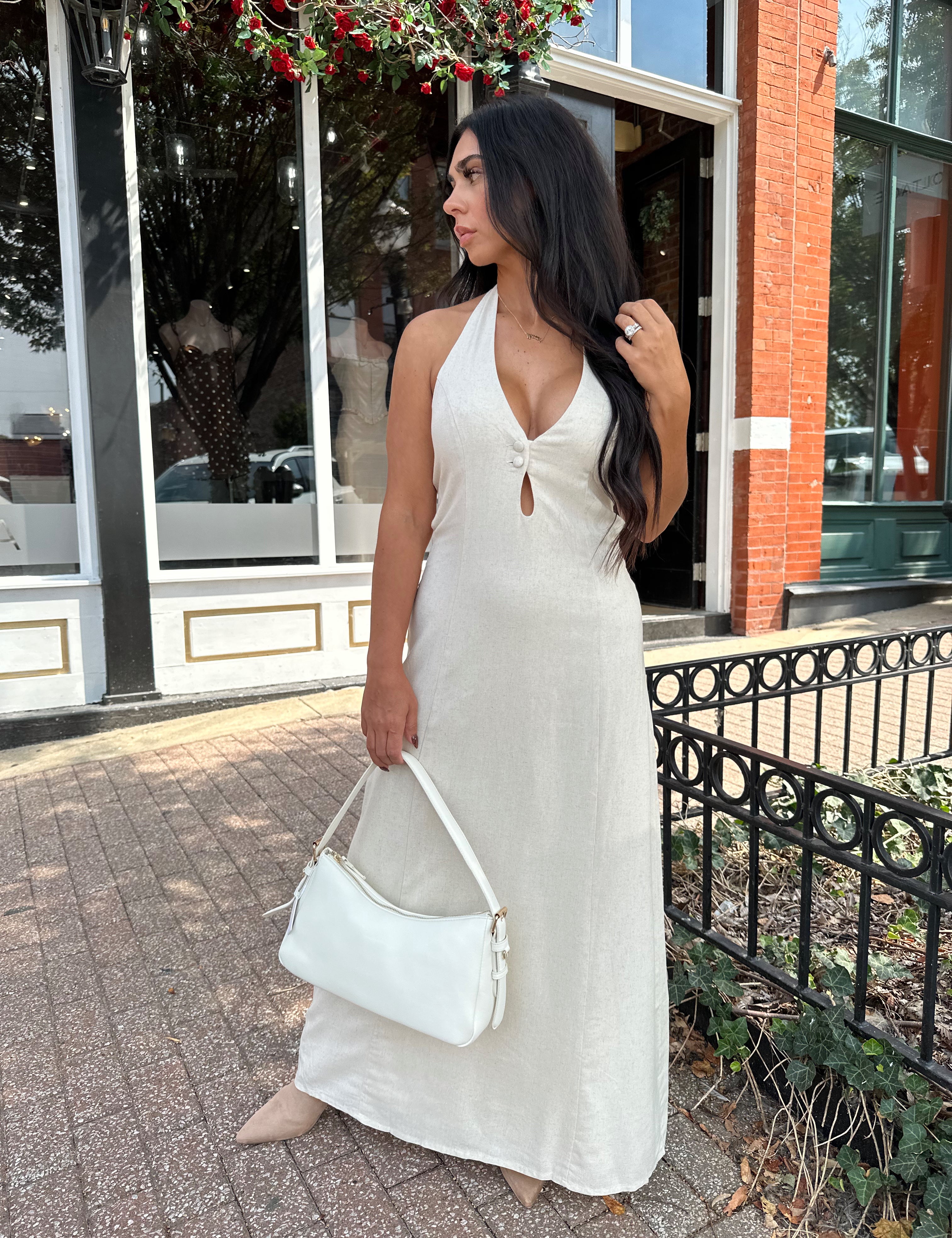 Woman wearing natural colored maxi dress with halter keyhole cutout neckline and tie back.
