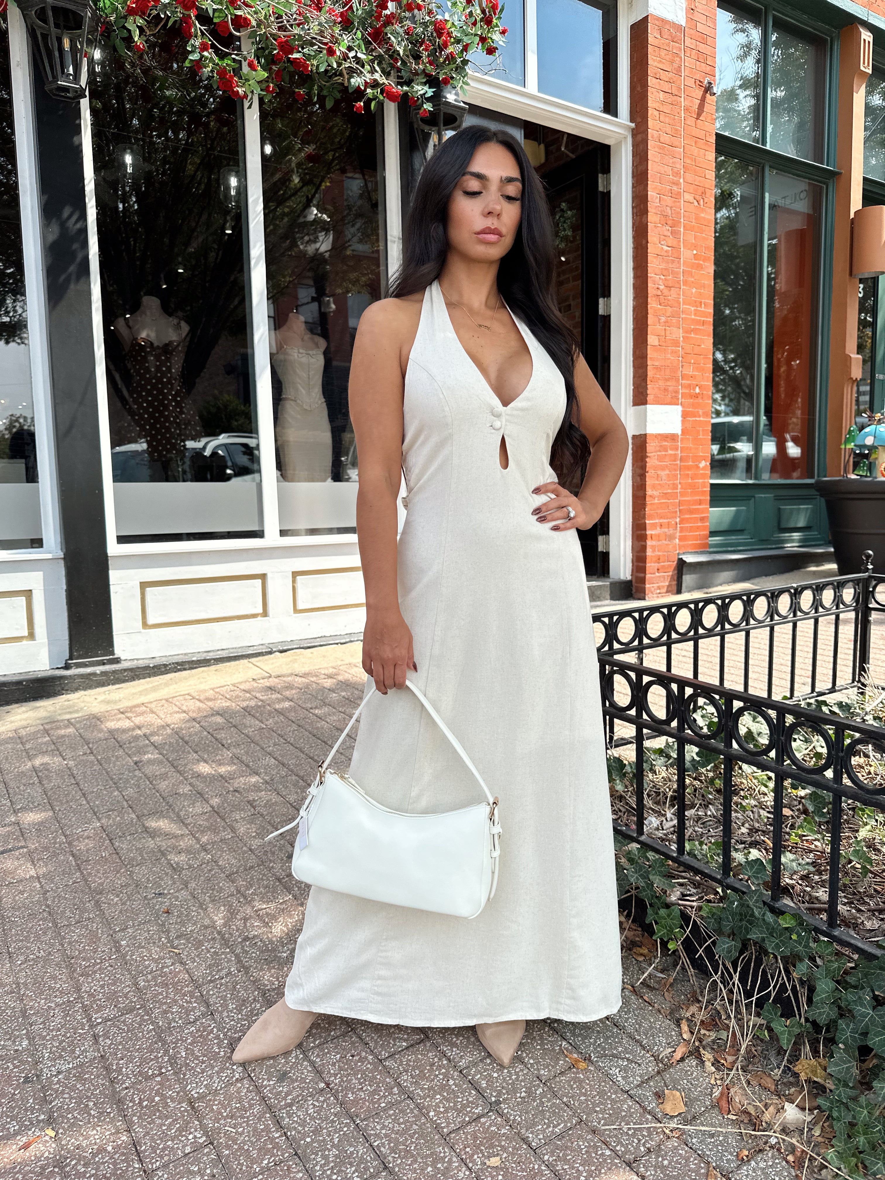 Woman wearing natural colored maxi dress with halter keyhole cutout neckline and tie back.