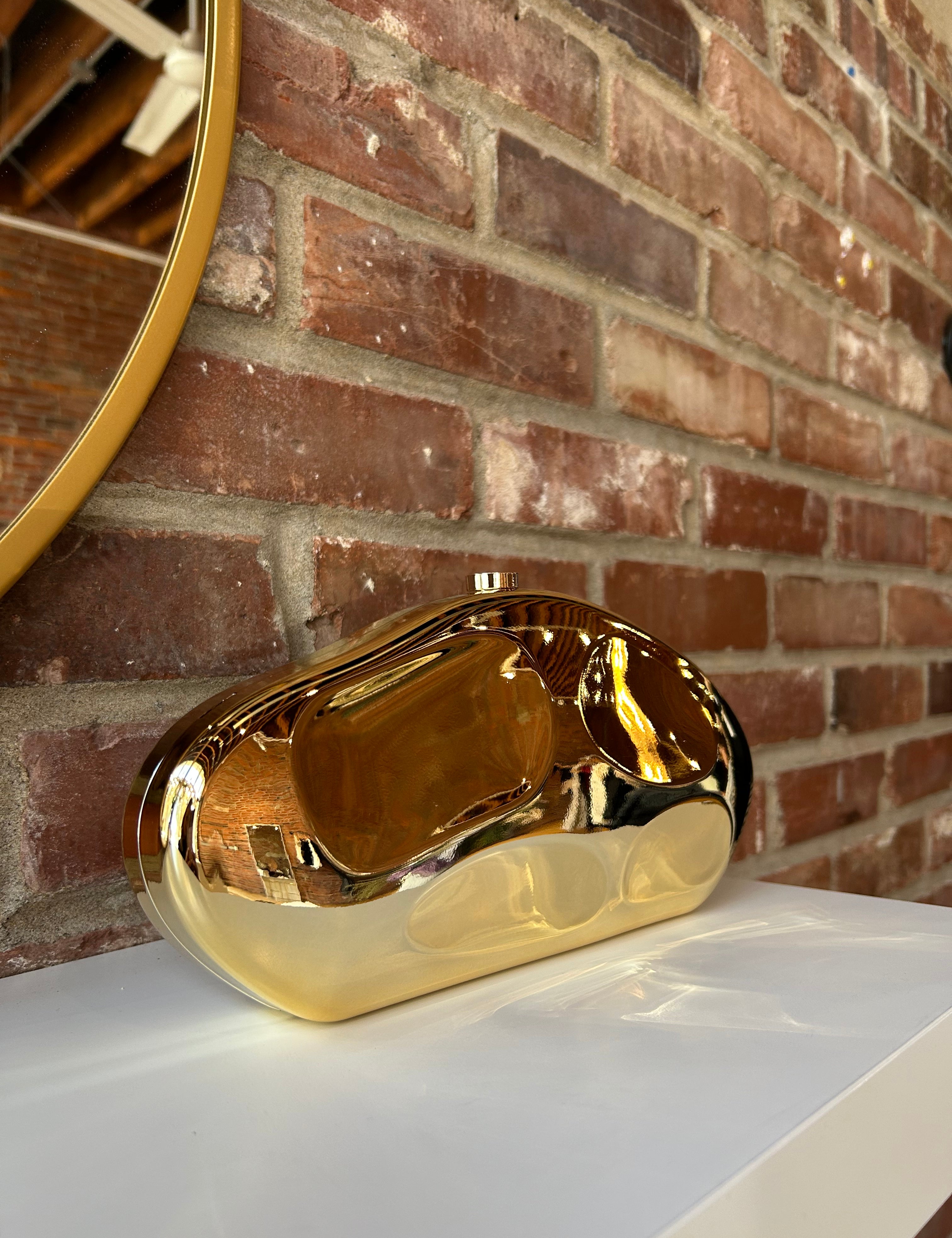 Gold hardshell clutch bag with detachable chain. 