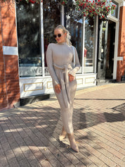 Woman wearing mocha long sleeve knit sweater dress with tie front detail. 