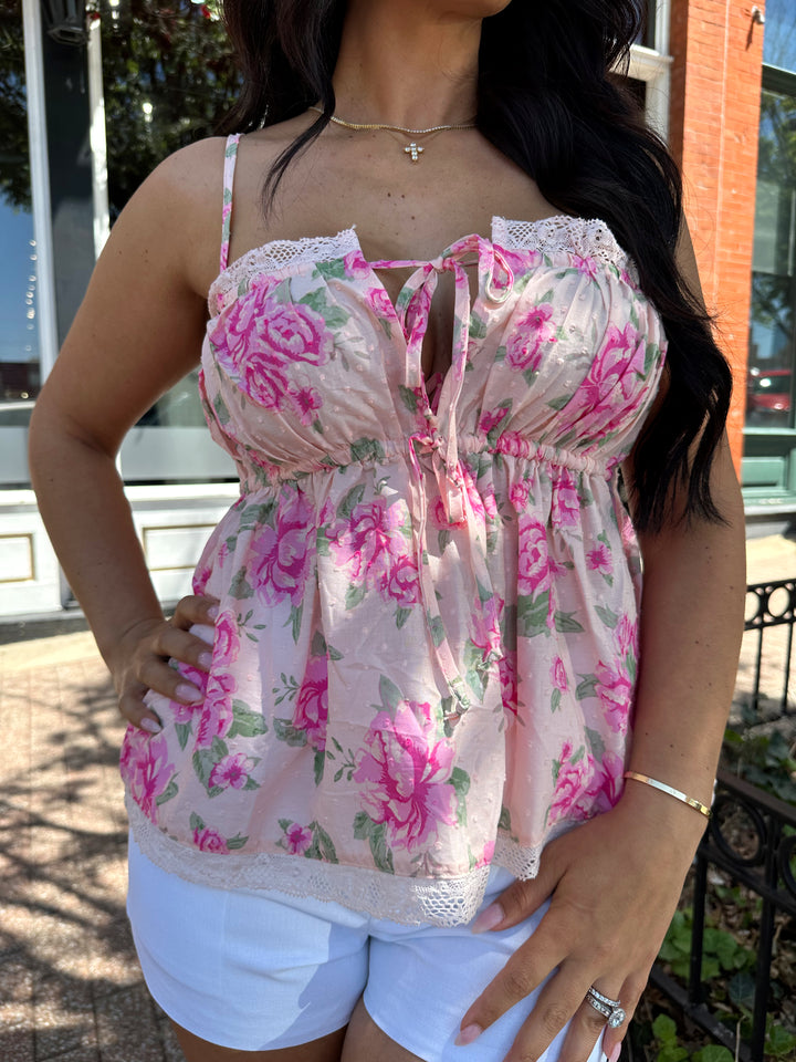 Woman wearing pink floral babydoll tank top with white micro shorts. 