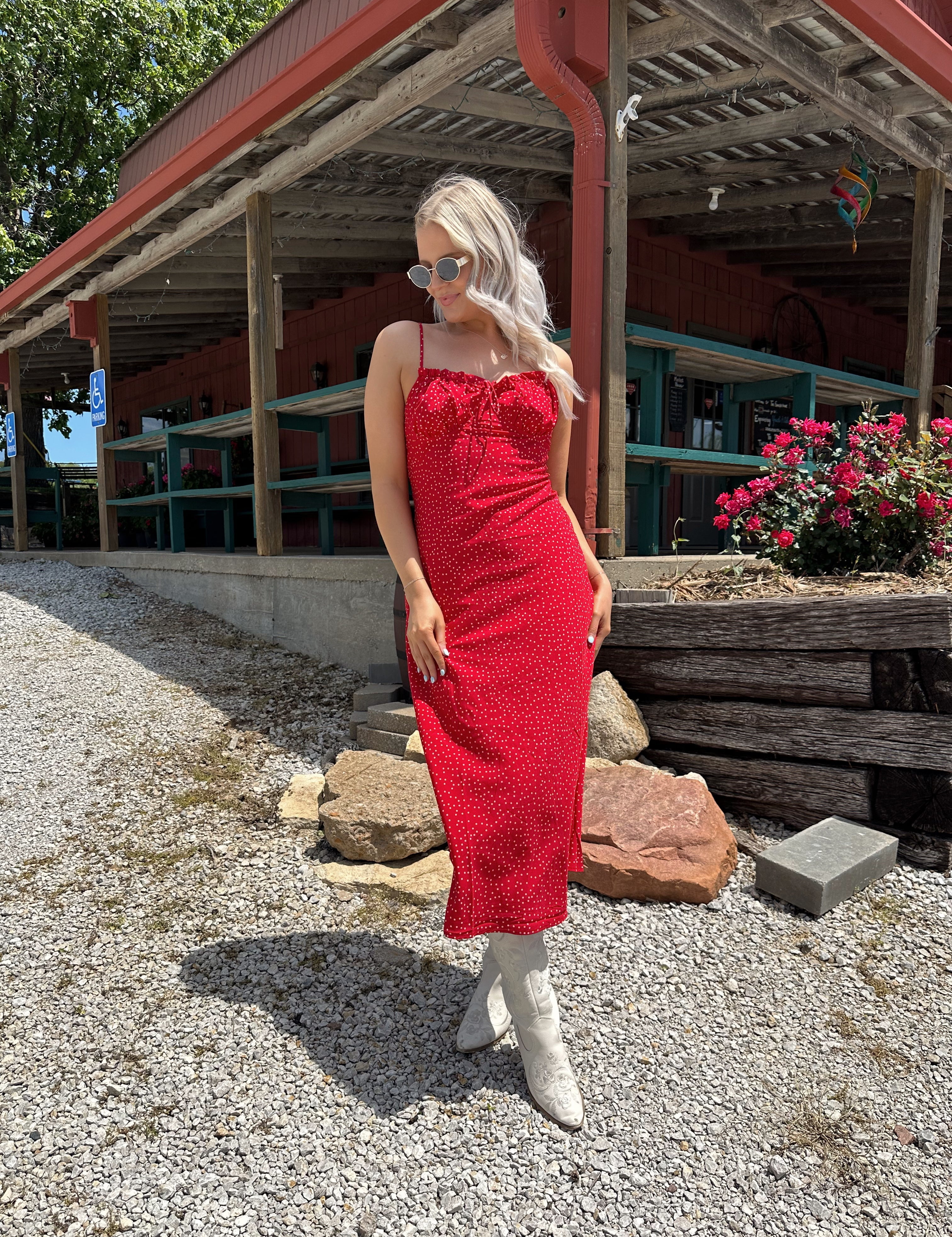 Red and white polka dot midi dress with adjustable spaghetti straps and tie neckline.