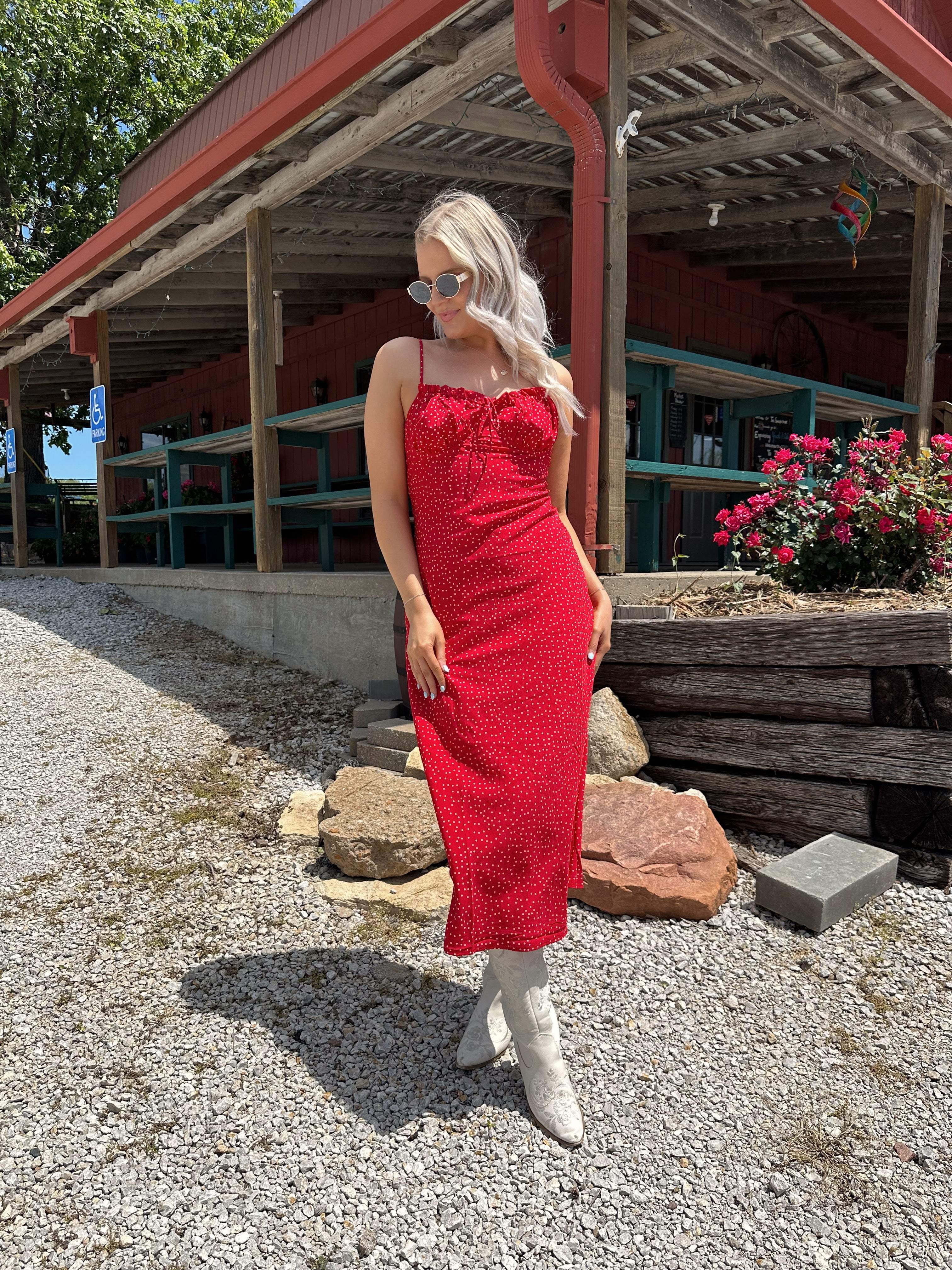Red and white polka dot midi dress with adjustable spaghetti straps and tie neckline.