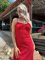 Red and white polka dot midi dress with adjustable spaghetti straps and tie neckline.